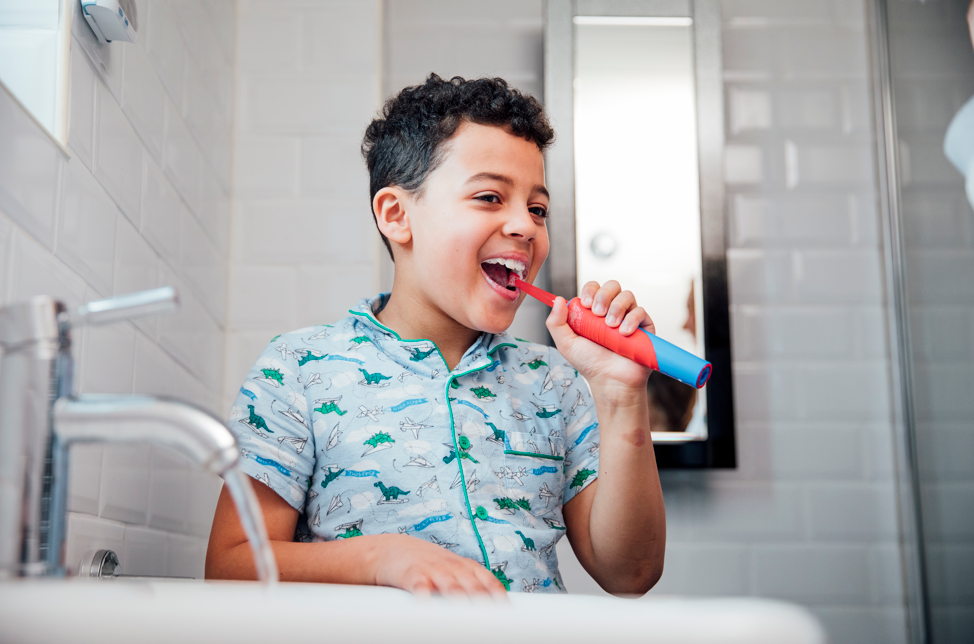 Young boy using electric toothbrush