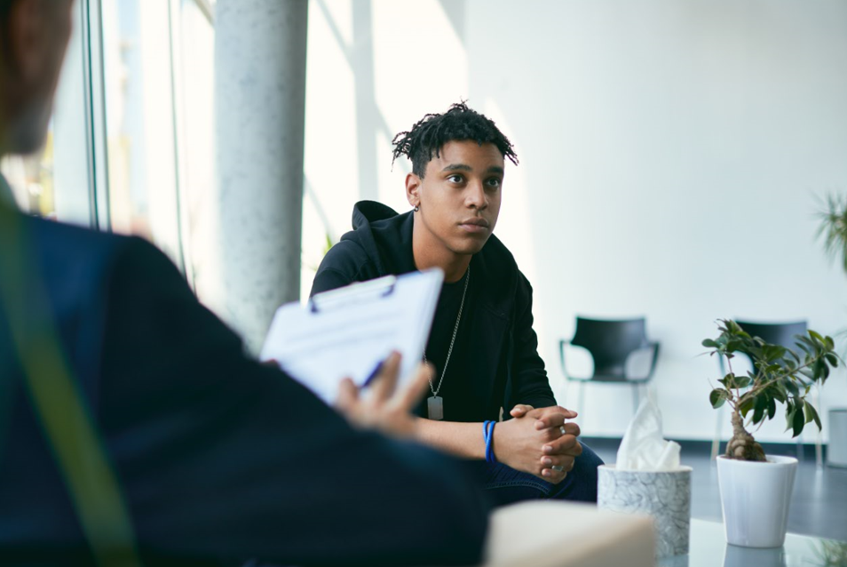 Teen boy talking with therapist.