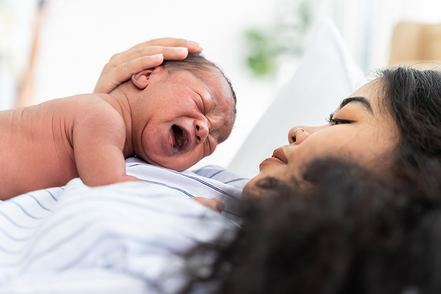 Mother holding newborn against her chest